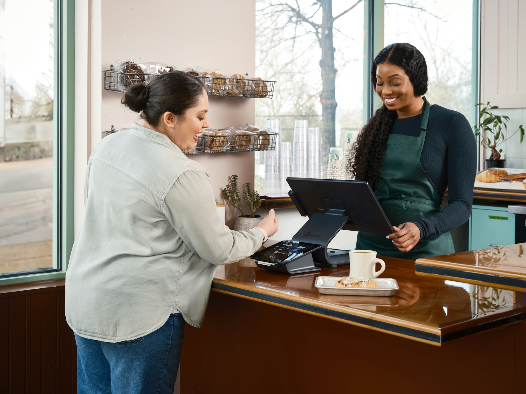 A customer paying at a bright café counter